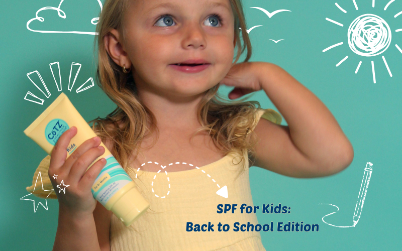 CoTZ kids lotion SPF blog image. Toddler girl holding CoTZ Kids Lotion on a blue background with chalk drawings