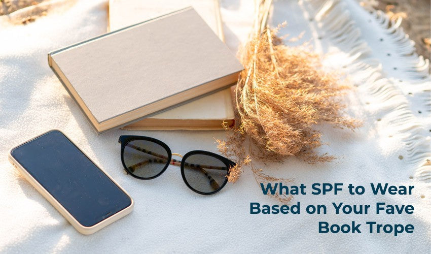 books, sunglasses, flowers, and phone laying on a blanket with text overlayed "what SPF to wear based on your fave book trope