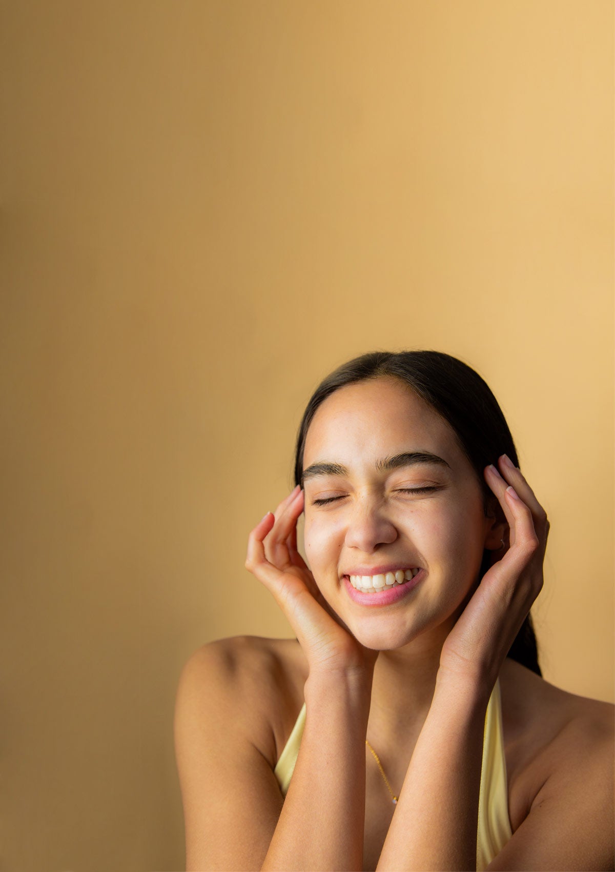 Image of smiling model framing her face with her hands wearing Face Moisture SPF 35