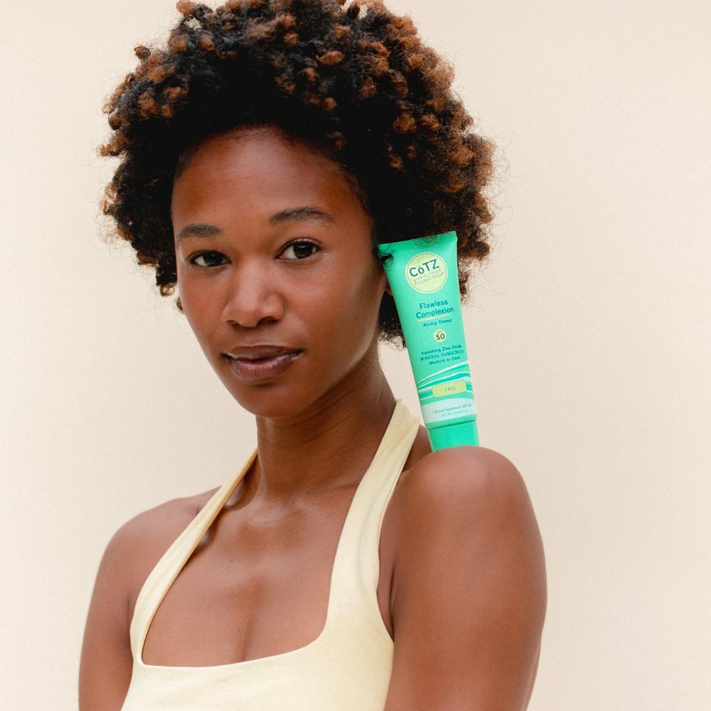 Image of model balancing Cotz Flawless Complexion Richly Tinted SPF 50 on her shoulder