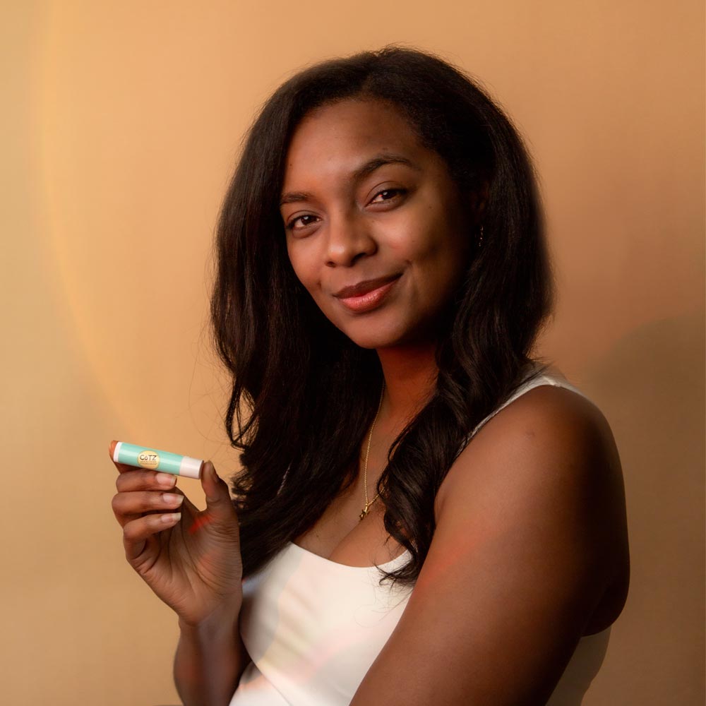 Image of model holding Cotz Lip Balm Tinted SPF 45