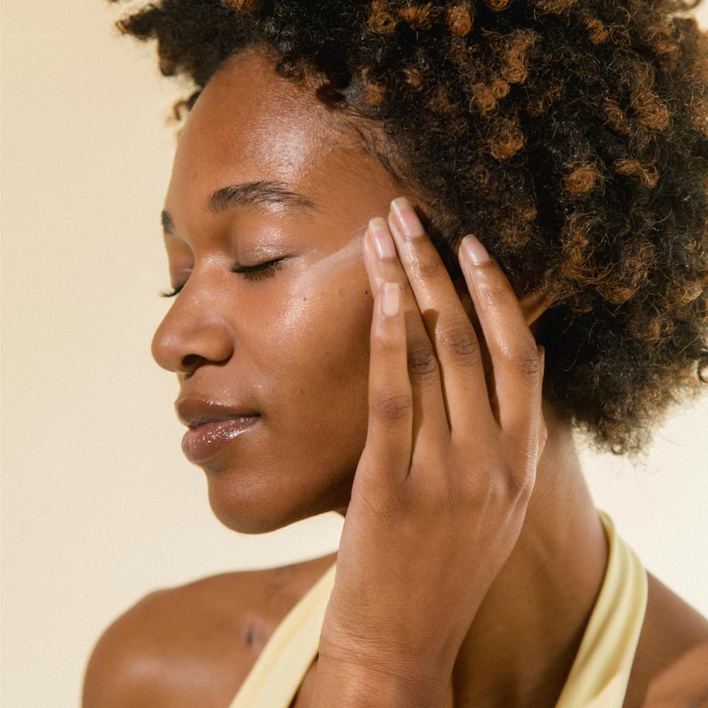 Image of model rubbing in a swatch of Cotz Face Prime & Protect Tinted SPF 40 on her cheek