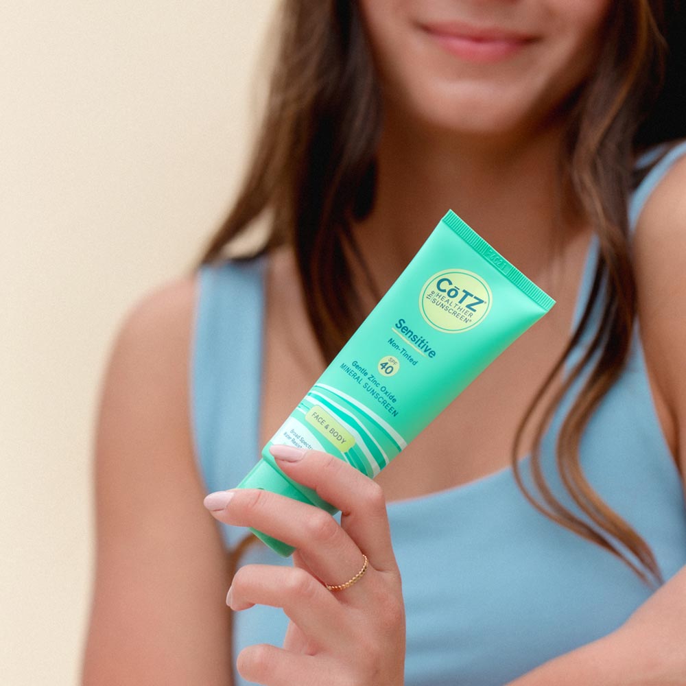 Image of model holding Cotz Sensitive Non-Tinted SPF 40