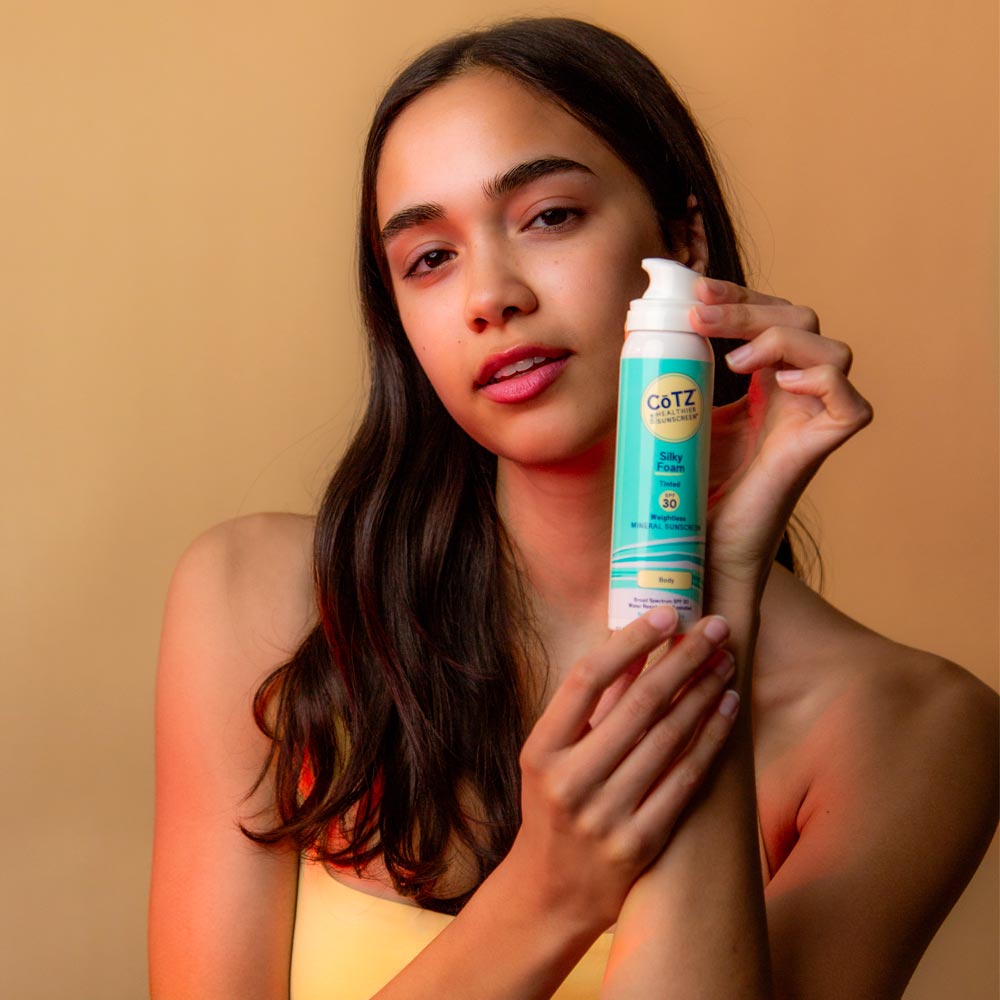 Image of model holding Cotz Silky Foam Tinted SPF 30 