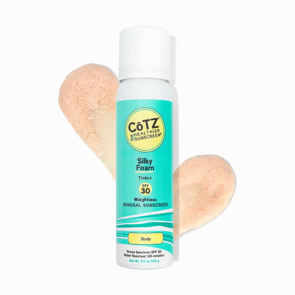 Image of Cotz Silky Foam Tinted SPF 30 tube with two swatches behind it on white background